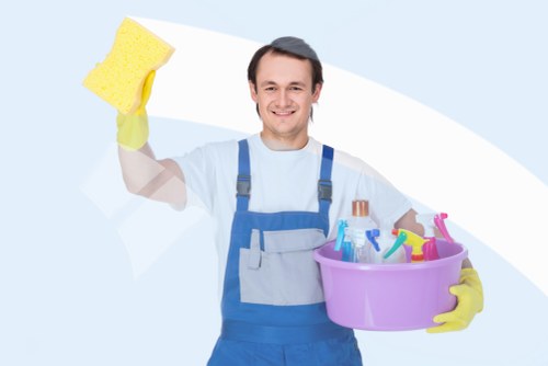 Carpet cleaning operative using safe working practices with equipment and protective measures